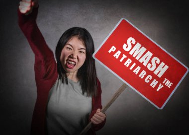 Genç agresif aşırı feminist Asyalı kadın elinde reklam panosu tutarken ataerkil metni kadın hakları ve kadın üstünlüğü için parçaladı.