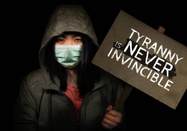 Genç kızgın Asyalı aktivist kız Çin zulmüne karşı protesto pankartı tutuyor. Hong Kong 'lu kadın Hong Kong özgürlüğünü protesto ediyor. 