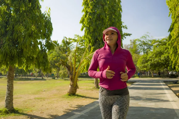 Atraente senhora de meia idade correndo feliz no parque da cidade. mulher bonita e desportiva em seus 40 anos exercitando-se fazendo jogging treino em uma manhã ensolarada desfrutando de um estilo de vida saudável — Fotografia de Stock