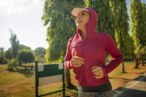 attractive middle aged lady running happy at city park . beautiful and sporty woman on her 40s exercising doing jogging workout on a sunny morning enjoying healthy lifestyle