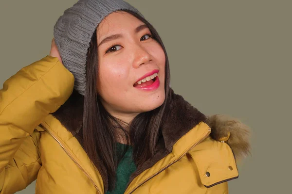 Retrato aislado de moda de la joven hermosa y feliz mujer china asiática en sombrero de invierno y chaqueta de plumas amarillas cálidas con capucha de piel gesto alegre y juguetón sonriente — Foto de Stock