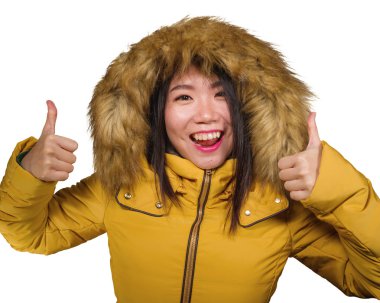 Güzel ve mutlu Asyalı, sarı tüylü ceketli, neşeli ve neşeli gülümseyen genç bir kadının kış modası portresi.