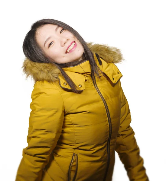 Зимняя мода изолированный портрет молодой красивой и счастливой азиатской женщины в теплой желтой перьевой куртке с меховым капюшоном жестом веселой и игривой улыбкой — стоковое фото