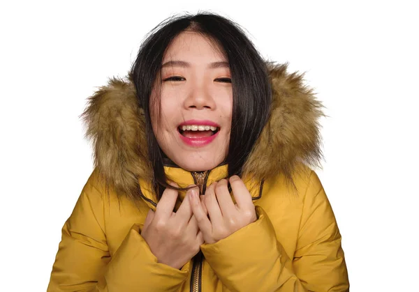 Moda de invierno retrato aislado de joven hermosa y feliz mujer coreana asiática en chaqueta de plumas amarillo cálido con capucha de piel gesto alegre y juguetón sonriente — Foto de Stock