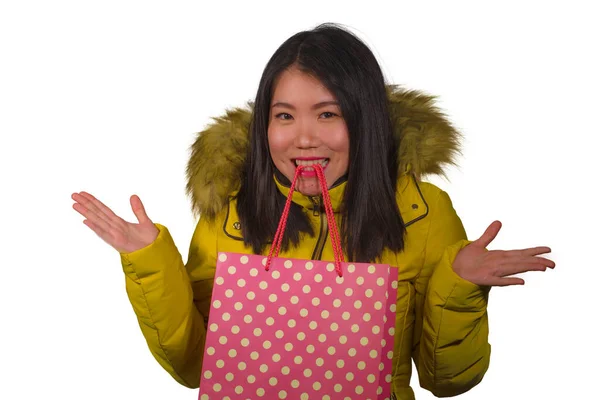 Jovem bonita e feliz mulher coreana asiática em casaco de inverno fresco segurando saco de compras animado comprando presente de Natal sorrindo alegre na moda e conceito de beleza isolado — Fotografia de Stock