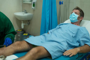 Çekici ve korkmuş bir adam kovid 19 'dan etkilenmiş. Yüz maskesi takmış yetişkin bir erkeğin dramatik portresi hastanede tedavi görüyor. Solunum hastalığından muzdarip. 