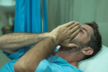 Korkmuş ve endişeli bir adam hastaneye kaldırıldı. Çekici yaralı bir adam hastanede yatıyor. Tedavi görüyor.