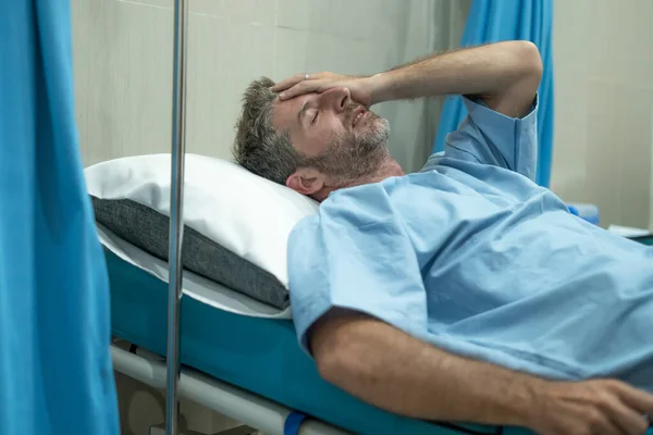 在医院病房里痛苦的害怕和忧虑的男人 漂亮的受伤男人躺在床上 痛苦的问题在经历了事故或严重的疾病之后感到身体不适和紧张 — 图库照片