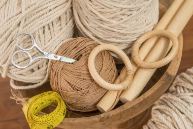 makasla bir kasede bulunan kablolar ve iplikler ve ölçü bantları hobi ve el yapımı makrome ev dekorasyonu için ahşap elementler içerir.