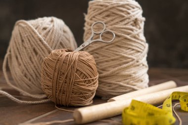 makasla bir kasede bulunan kablolar ve iplikler ve ölçü bantları hobi ve el yapımı makrome ev dekorasyonu için ahşap elementler içerir.