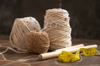 makasla bir kasede bulunan kablolar ve iplikler ve ölçü bantları hobi ve el yapımı makrome ev dekorasyonu için ahşap elementler içerir.