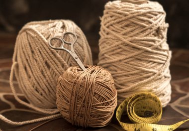 makasla bir kasede bulunan kablolar ve iplikler ve ölçü bantları hobi ve el yapımı makrome ev dekorasyonu için ahşap elementler içerir.