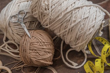 makasla bir kasede bulunan kablolar ve iplikler ve ölçü bantları hobi ve el yapımı makrome ev dekorasyonu için ahşap elementler içerir.