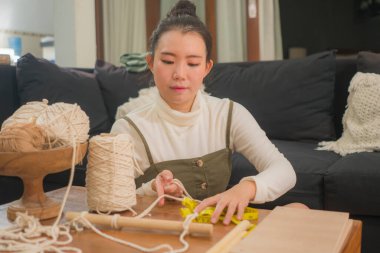 Kadın elleri makrome el sanatları hobisi yapıyor. Ev yapımı el yapımı dekorasyon ipleri, ipler ve iplerle makrome ağ ören kadının elleri.
