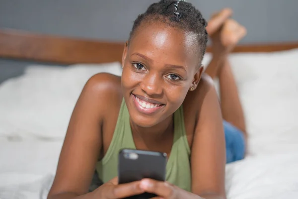 행복하고 매력적 침대에 미디어 사용하여 핸드폰에서 편안하고 즐거운 온라인 데이트를 — 스톡 사진