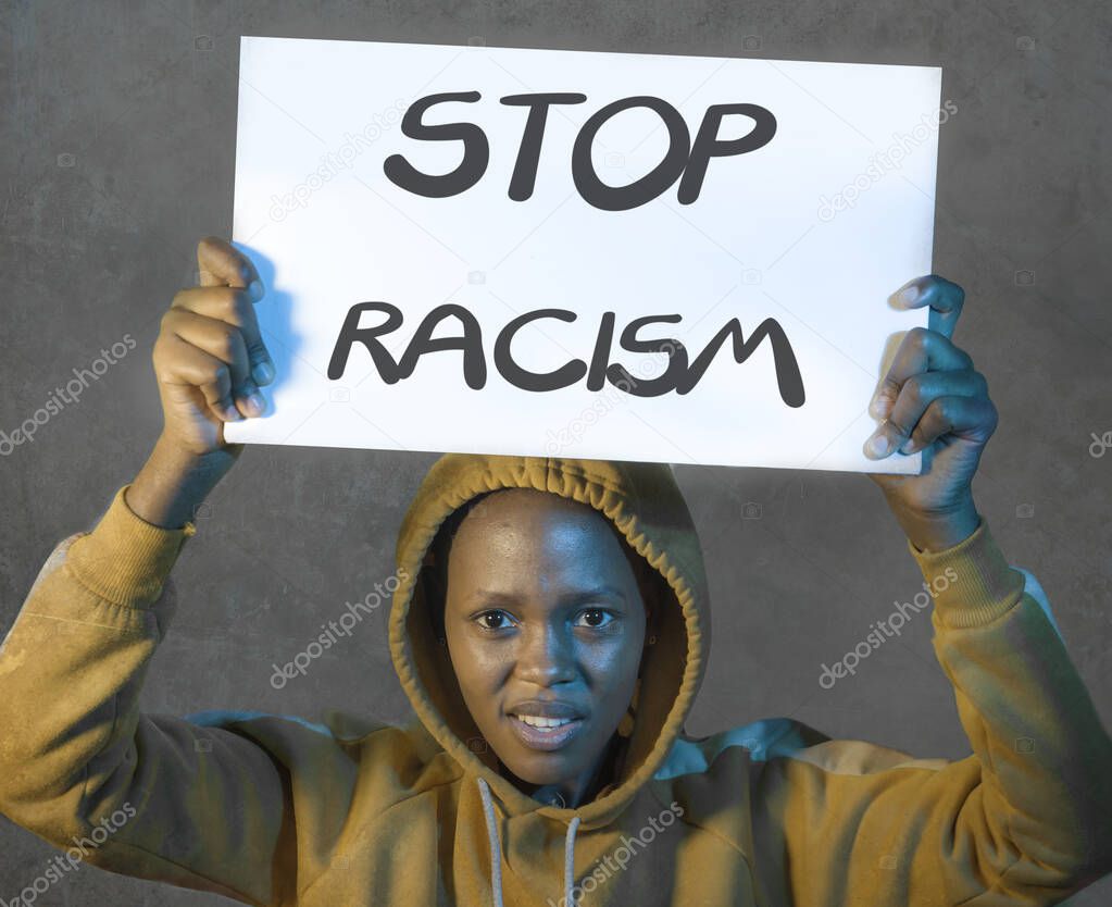 stop racism black activist girl protesting against government - young beautiful and furious African American woman in hoodie showing protest banner demanding stop racial discrimination 