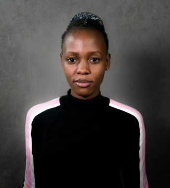 Çekici ve kendine güvenen siyah Afrikalı Amerikalı kadının portresi. Havalı bir şekilde poz veriyor. Grunge arka planında izole edilmiş kameraya bakıyor.