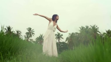 Doğa ile beden ve zihin bağlantısı - mutlu ve güzel Asyalı Japon kadın dışarıda yoga yapıyor ve meditasyon yapıyor. Cennet gibi yeşil pirinç tarlasında tropikal yaz tatillerinin tadını çıkarıyor.