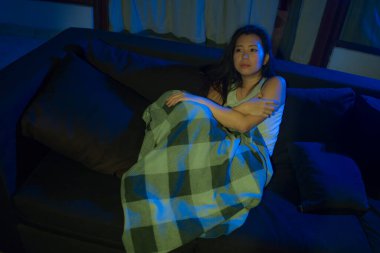 Genç, üzgün ve depresif Asyalı bir kadının dramatik ev hayatı portresi oturma odasındaki kanepede yatıyor kırık bir kalp depresyon ve anksiyete acısı çekiyor.