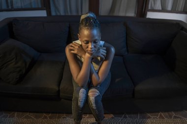 Milenyum kuşağı Afro-Amerikan kızı geceleri depresyona giriyor. Genç, üzgün ve depresif siyah kadın düşünceli ve endişeli bir şekilde kanepeye oturuyor. Acı ve korku içinde. 