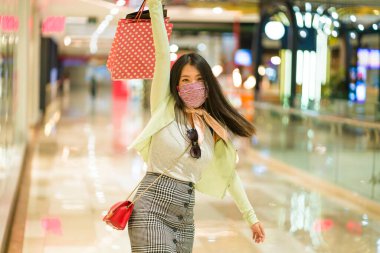 Yeni normal alışkanlıklar. Alışveriş merkezindeki genç, çekici ve mutlu Asyalı Japon kadın. Mutluluk ve heyecan. 