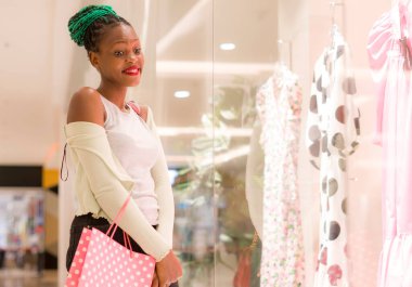 Genç, mutlu ve güzel Afro-Amerikan kız alışveriş merkezi satın alıyor. Bin yıllık siyahi bir kızın hayat tarzı. Güzellik mağazasında giyinmekten zevk alıyor ve eğleniyor.