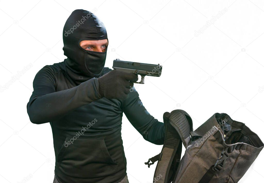 heist and robbery - Hollywood style portrait of man in balaclava mask holding gun in front of security metal vault door in bank or casino heist concept stealing money unlocking safe isolated white background