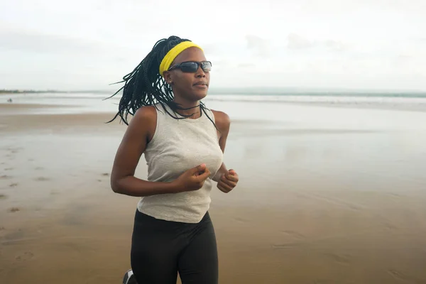 ビーチで走るアフリカ系アメリカ人女性 若い魅力的で運動能力のある黒人女性のトレーニングアウトドアフィットネスや健康的なライフスタイルのコンセプトで海でジョギングワークアウトを行う — ストック写真