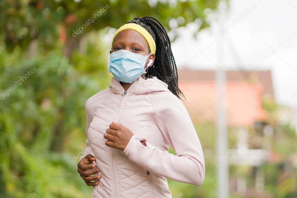 post quarantine runner girl enjoying outdoors workout - young attractive and fit black afro American woman running wearing face mask in new normal sport practice concept and healthy lifestyle