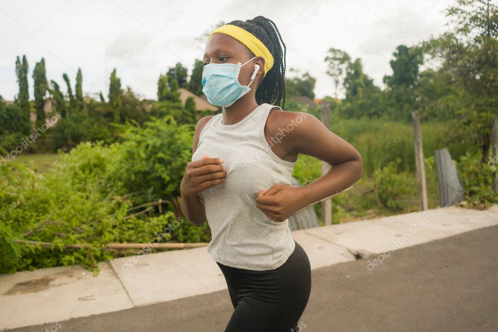 post quarantine runner girl enjoying outdoors workout - young attractive and fit black African American woman running wearing face mask in new normal sport practice concept and healthy lifestyle