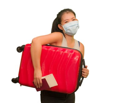 Yeni normal seyahat. Mutlu ve güzel Asyalı kadın. Yüz maskeli. Kovid19 karantinasından sonra tatilin tadını çıkarmaya hazır bavul taşıyor.