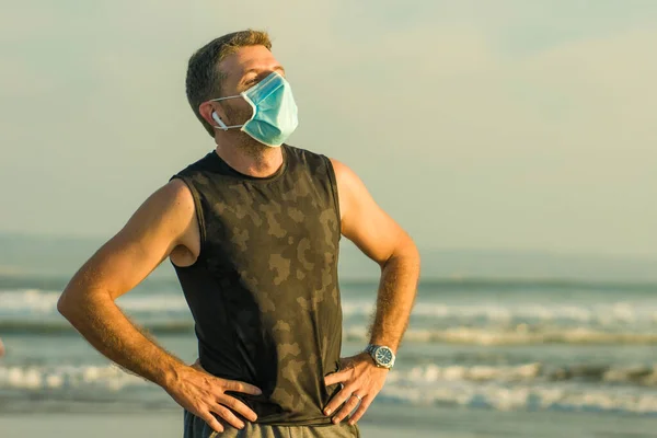 新的正常的海滩慢跑锻炼 有魅力 戴着面具 呼吸疲惫的男人 在经历了围攻之后 在海上训练后又恢复了镇静 — 图库照片