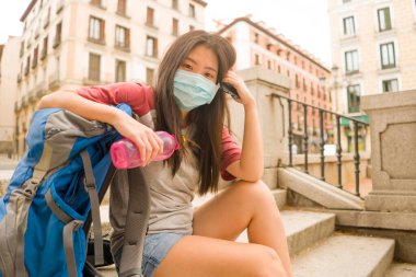 Avrupa 'da yeni normal tatil seyahatleri. Yüz maskesi ve sırt çantasıyla Asya' da yaşayan güzel ve mutlu bir Çinli turist. Şehir turunun keyfini çıkarıyorlar.