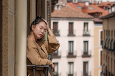 Depresyon ve anksiyete krizi geçiren mutsuz ve endişeli genç, üzgün Asyalı bir kadının dramatik portresi.