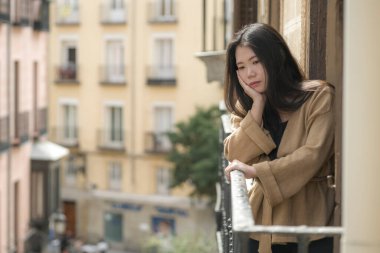 Depresyon ve anksiyete krizi geçiren mutsuz ve endişeli genç, üzgün Asyalı bir kadının dramatik portresi.