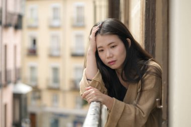 Depresyon ve anksiyete krizi geçiren mutsuz ve endişeli genç, üzgün Asyalı bir kadının dramatik portresi.