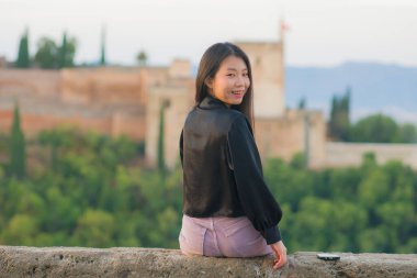 Genç, güzel ve mutlu Asyalı Koreli bir turistin Avrupa 'da yaz tatilinde İspanya' nın güzel Alhambra 'sını ziyaret edişinin hayat tarzı portresi.