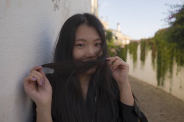 Avrupa 'da yaz tatilinin tadını çıkaran güzel ve mutlu Asyalı bir kadının hayat tarzı portresi İspanya' nın Endülüs köyünde turizm ve seyahat konseptiyle neşeli bir şekilde yürüyor. 