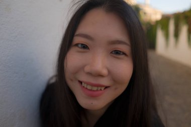 Avrupa 'da yaz tatilinin tadını çıkaran güzel ve mutlu Asyalı bir kadının hayat tarzı portresi İspanya' nın Endülüs köyünde turizm ve seyahat konseptiyle neşeli bir şekilde yürüyor. 