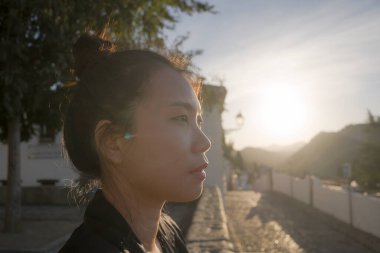 Avrupa 'da yaz tatilinin tadını çıkaran güzel ve mutlu Asyalı bir kadının hayat tarzı portresi İspanya' nın Endülüs köyünde turizm ve seyahat konseptiyle neşeli bir şekilde yürüyor. 