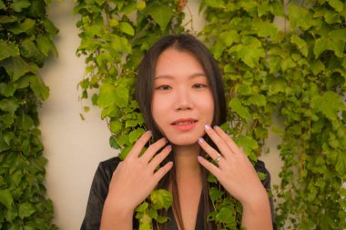 Genç mutlu ve güzel Asyalı Japon kadının hayat tarzı portresi köy bahçesinde poz veriyor. Güzel moda ve özgürlük kavramında neşeli ve neşeli.