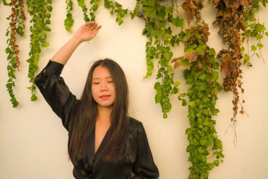 Genç mutlu ve güzel Asyalı kadının hayat tarzı portresi köy bahçesinde poz vermenin keyfini çıkarıyor. Güzel moda ve özgürlük kavramında neşeli ve neşeli.