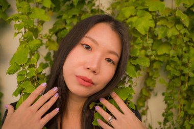 Genç mutlu ve güzel Asyalı kadının hayat tarzı portresi köy bahçesinde poz vermenin keyfini çıkarıyor. Güzel moda ve özgürlük kavramında neşeli ve neşeli.