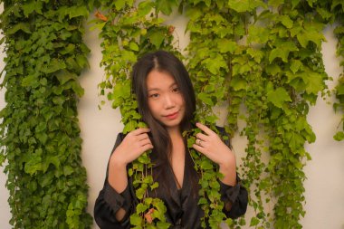 Genç mutlu ve güzel Asyalı kadının hayat tarzı portresi köy bahçesinde poz vermenin keyfini çıkarıyor. Güzel moda ve özgürlük kavramında neşeli ve neşeli.