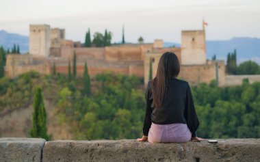 İspanya 'da yaz tatili geçiren güzel ve rahat genç bir kadının portresi. Turizm ve yaşam tarzı konseptiyle ilgili Alhambra Granada' nın güzel manzarasının keyfini çıkarıyor.