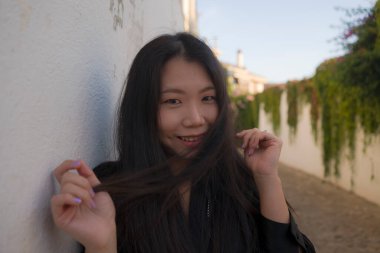 Avrupa 'da yaz tatilinin tadını çıkaran güzel ve mutlu Asyalı Çinli kadının yaşam tarzı portresi İspanya' nın Endülüs köyünde turizm ve seyahat konseptiyle neşeli bir şekilde yürüyor. 