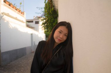 Avrupa 'da yaz tatilinin tadını çıkaran güzel ve mutlu Asyalı Çinli kadının yaşam tarzı portresi İspanya' nın Endülüs köyünde turizm ve seyahat konseptiyle neşeli bir şekilde yürüyor. 