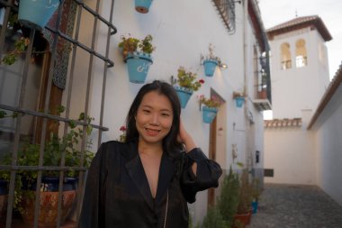 Avrupa 'da yaz tatilinin tadını çıkaran güzel ve mutlu Asyalı Japon kadının hayat tarzı portresi İspanya' nın Endülüs köyünde turizm ve seyahat konseptiyle neşeli bir şekilde yürüyor. 