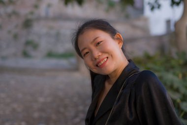 Avrupa 'da yaz tatilinin tadını çıkaran güzel ve mutlu Asyalı Japon kadının hayat tarzı portresi İspanya' nın Endülüs köyünde turizm ve seyahat konseptiyle neşeli bir şekilde yürüyor. 