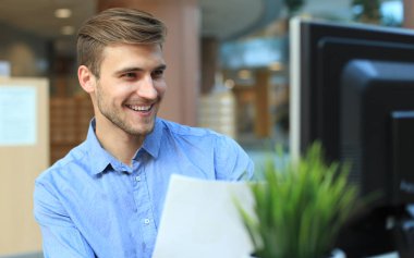 genç işadamı masasında Office belgeleri okuma.